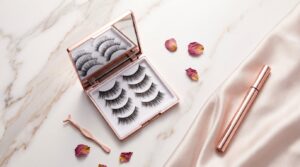 Elegant flat lay of magnetic eyelashes product kit on a marble surface with mirrored compact case and magnetic eyeliner pen